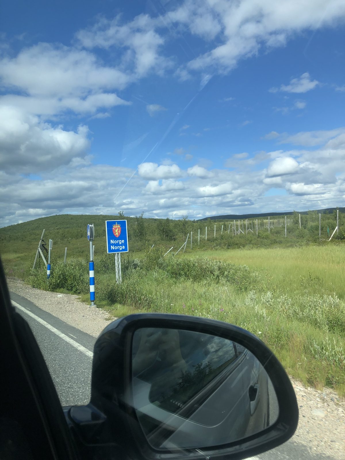 View from a car window at the Finland–Norway border sign